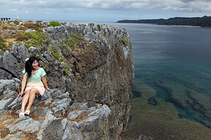 崖沿いに座る女性