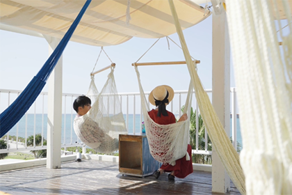 ハンモックに揺られながら景色を眺める男女