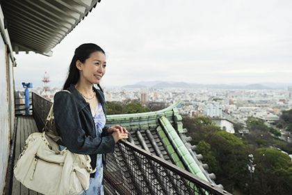 天守閣から景色を眺める女性
